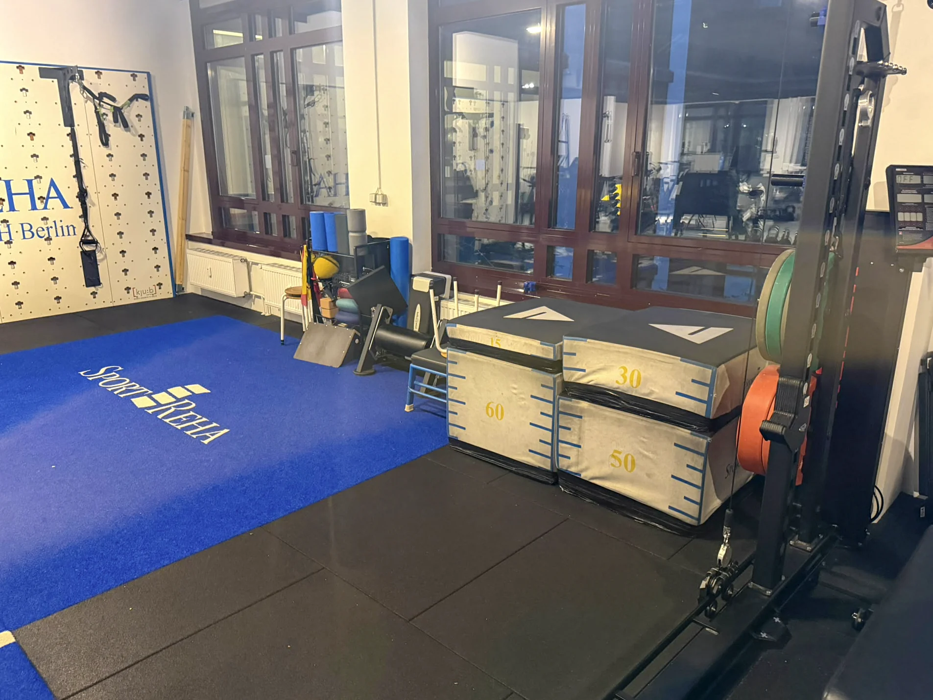 Funktioneller Trainingsbereich mit Boxen, Gewichten und Trainingsbahn in der Sport-REHA Berlin