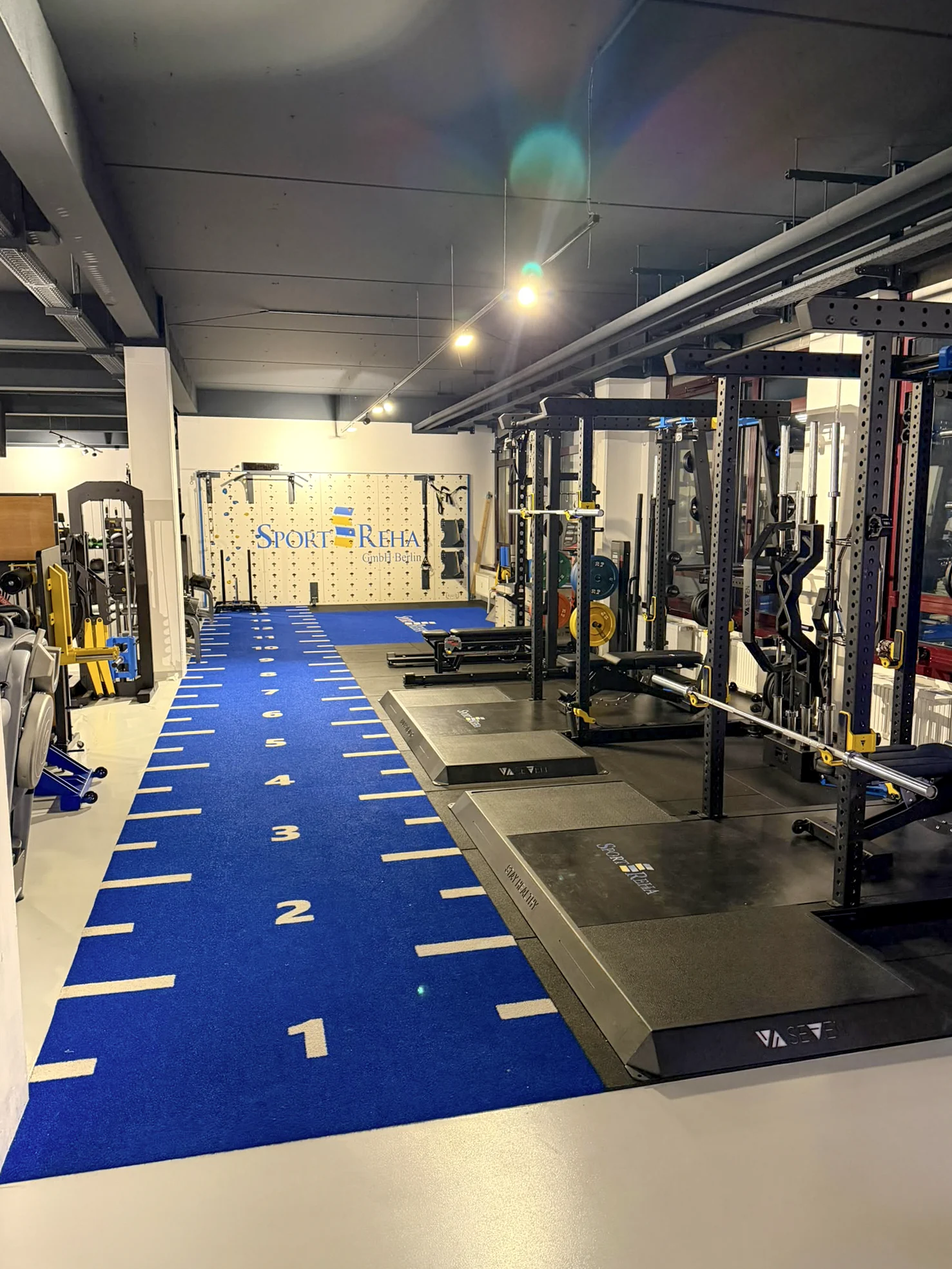 Blaue Trainingsbahn und Kraftgeräte in der Sport-REHA Berlin